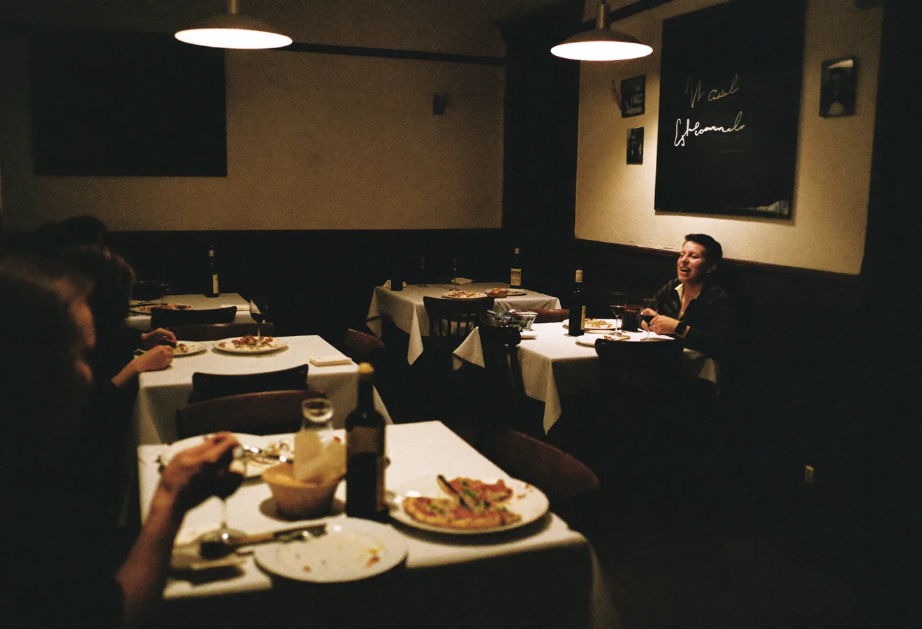 Gastraum einer Trattoria im Abendservice, Gäste an gedeckten Tischen